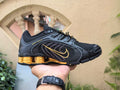 Nike Shox Low-Top Sneakers in Black and Gold - product image from the listing.