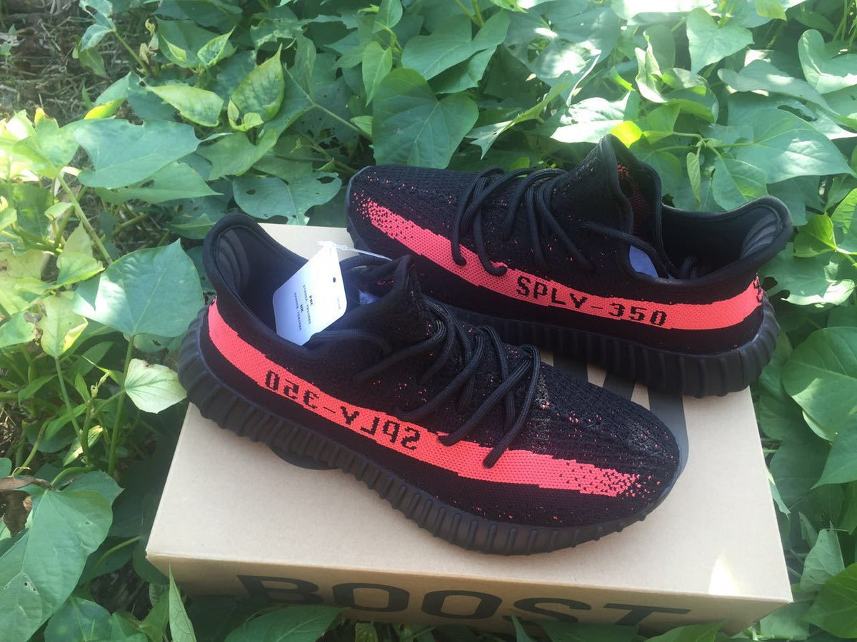 Yeezy Boost 350 V2 Sneakers in Black and Bright Coral - product image from the listing.