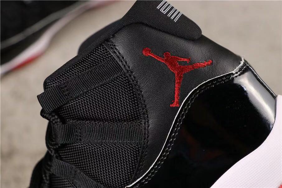 Air Jordan 11 Retro Bred High-Top Sneakers in Black and Red - product image from the listing.