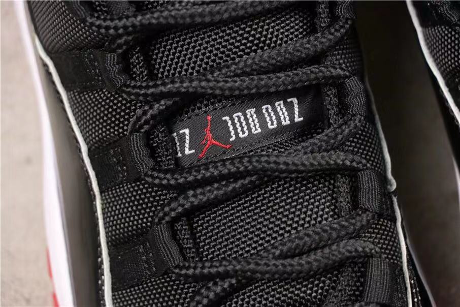 Air Jordan 11 Retro Bred High-Top Sneakers in Black and Red - product image from the listing.