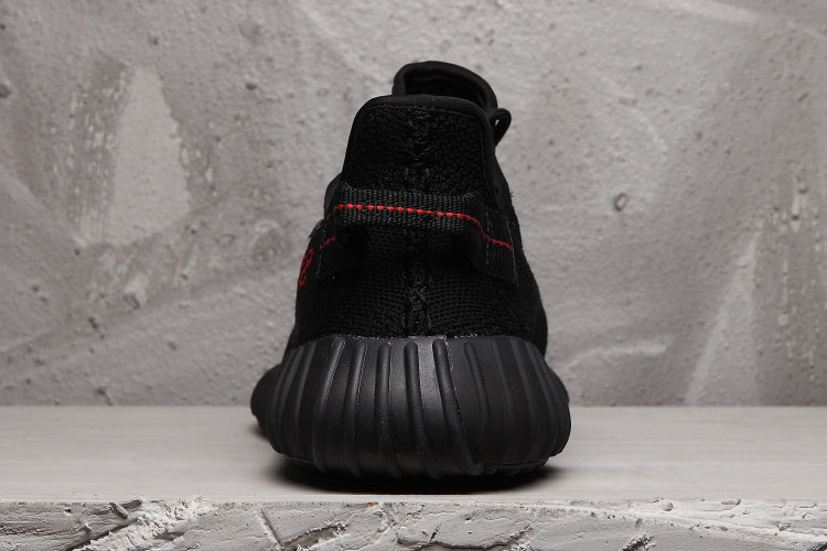 Yeezy Boost 350 V2 Black Knit Trainers with Red Accents - product image from the listing.