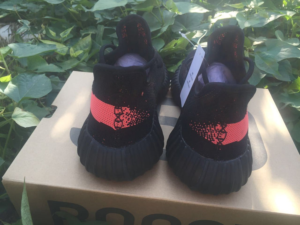 Yeezy Boost 350 V2 Sneakers in Black and Bright Coral - product image from the listing.