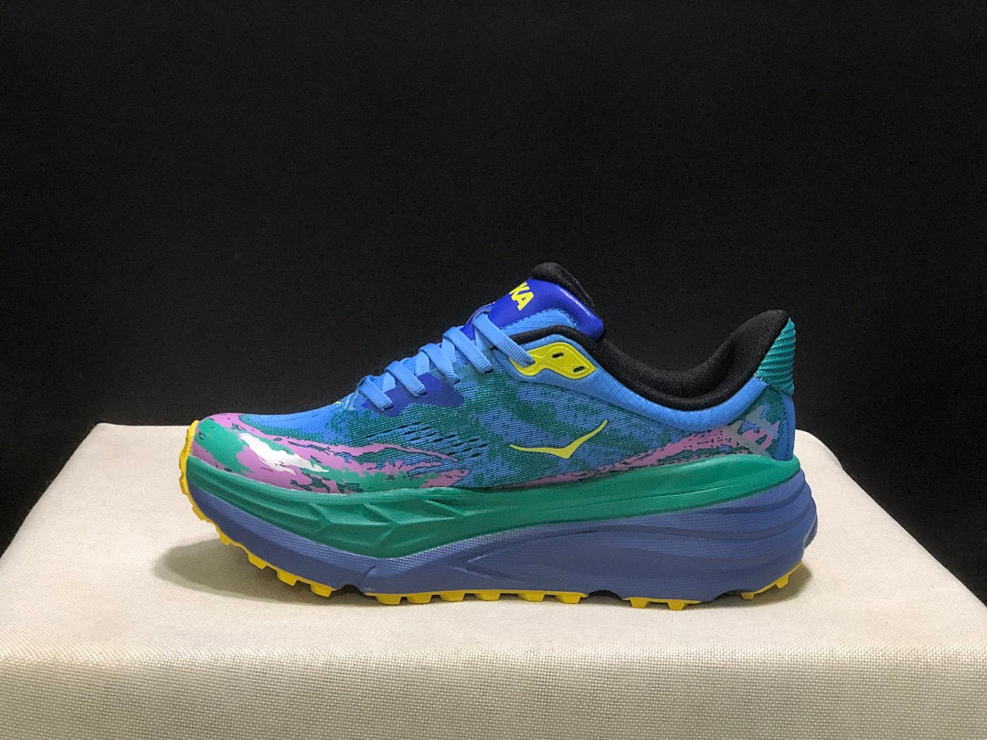 HOKA Stinson 7 Trail Sneakers in Blue Green Pink Yellow - product image from the listing.