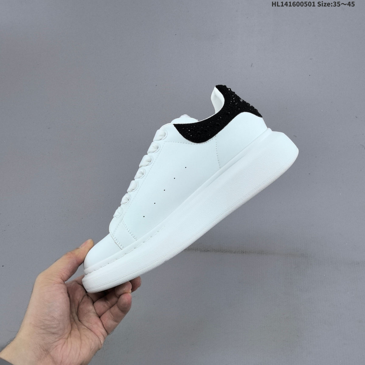 Alexander McQueen Oversized White Low-Cut Sneakers with Black Heel - product image from the listing.