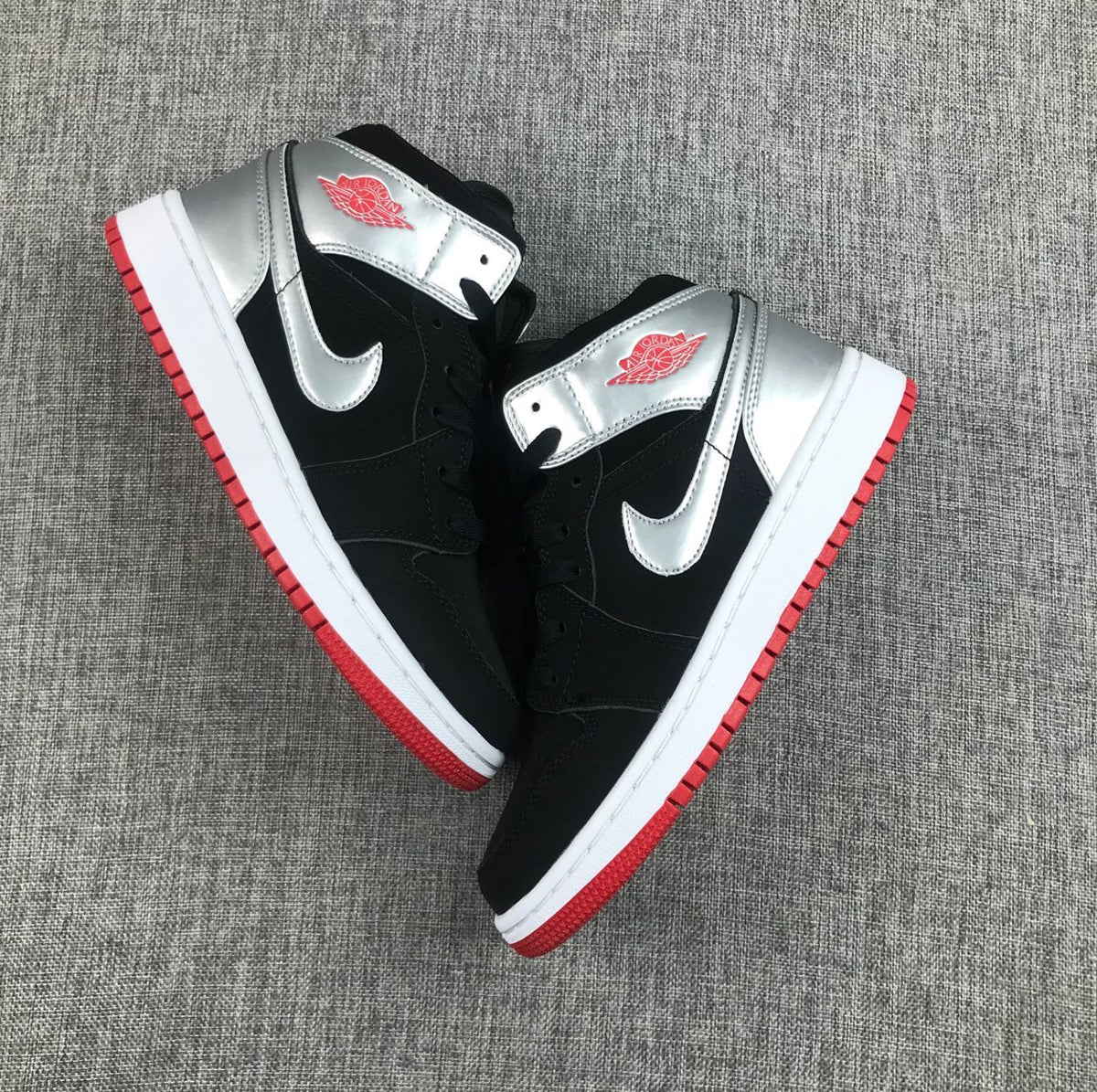 Air Jordan 1 Mid SE GS Sneakers in Black Silver 554725-057 - product image from the listing.
