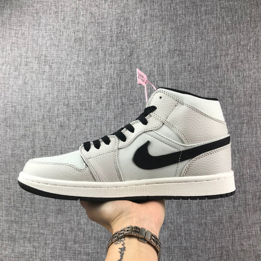 Air Jordan 1 Mid High-Top Sneakers in Grey and Black - product image from the listing.