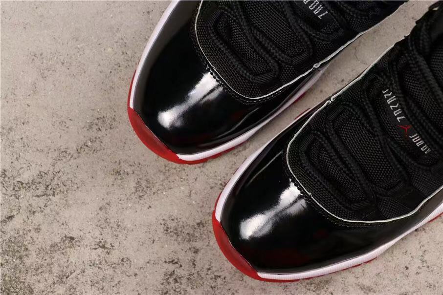 Air Jordan 11 Retro Bred High-Top Sneakers in Black and Red - product image from the listing.