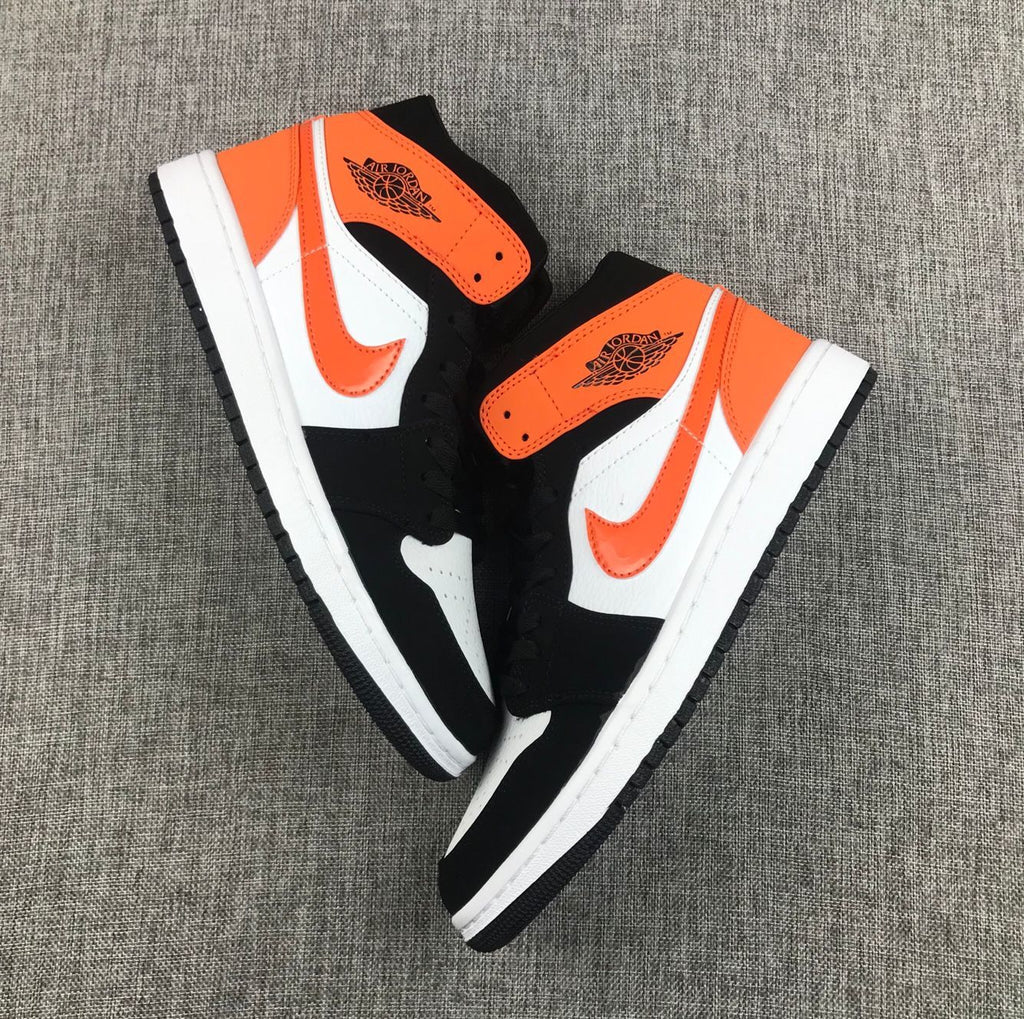 Air Jordan 1 Mid Sneakers in Black White Orange 554724-058 - product image from the listing.
