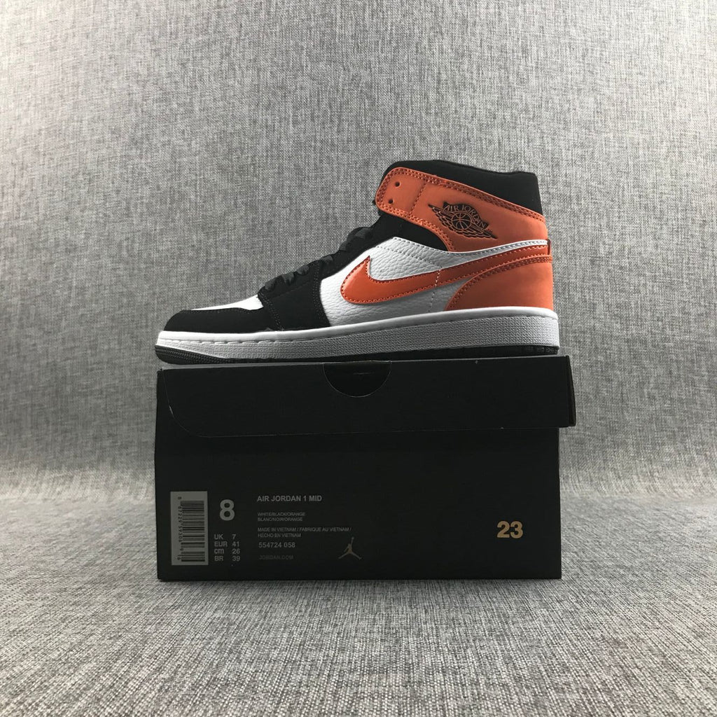 Air Jordan 1 Mid Sneakers in Black White Orange 554724-058 - product image from the listing.