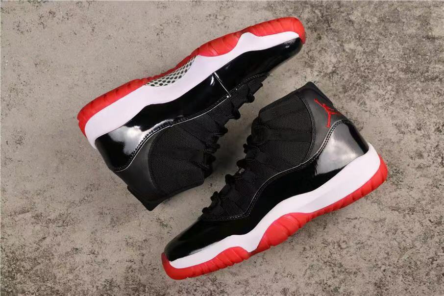 Air Jordan 11 Retro Bred High-Top Sneakers in Black and Red - product image from the listing.