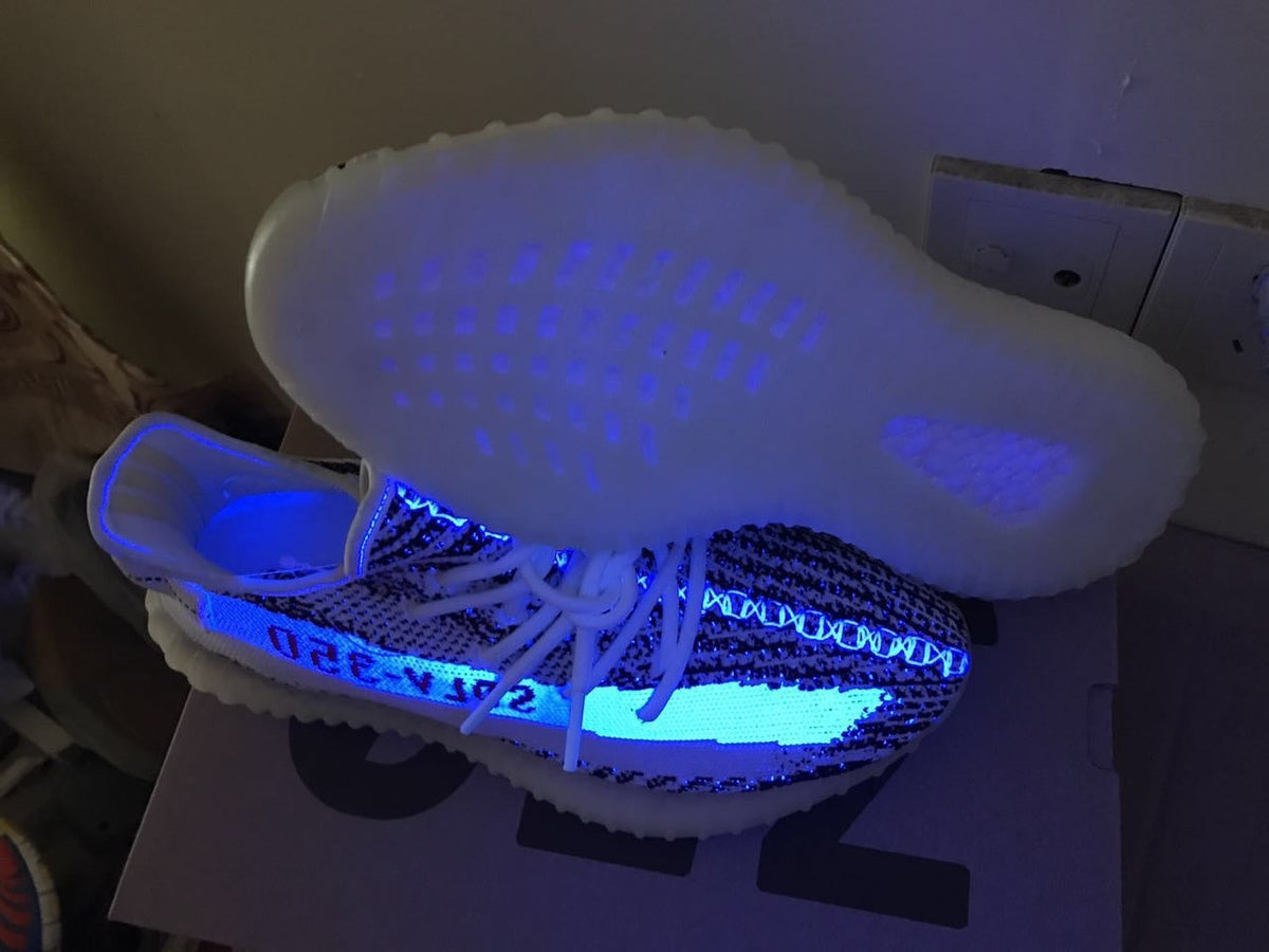 Yeezy 350 V2 Glow-in-the-Dark Sneakers, in Black and White - product image from the listing.