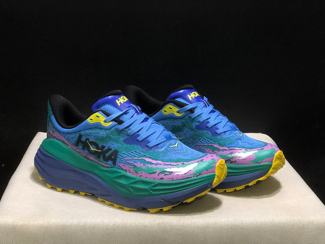 HOKA Stinson 7 Trail Sneakers in Blue Green Pink Yellow - product image from the listing.